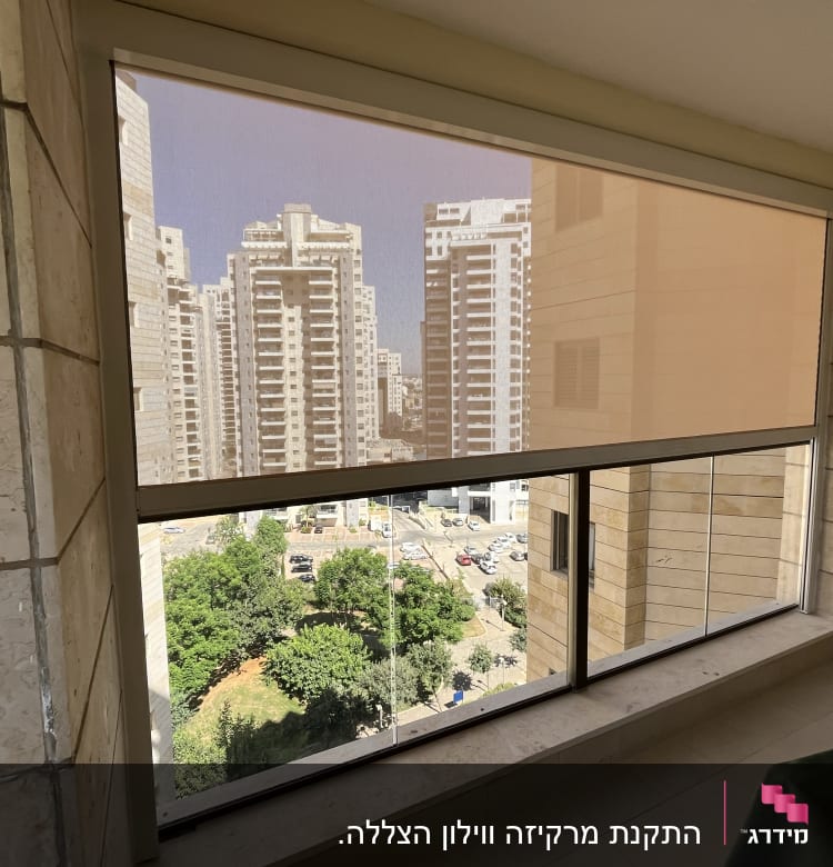 מרפסת עם סוכך גלילה חצי שקוף על חלון גדול